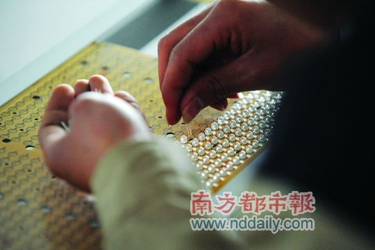 工人忙著安裝用于燈具發(fā)光的LED燈珠，這類工作處于LED燈具生產(chǎn)的最下游。資料圖
